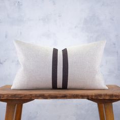 two black and white pillows sitting on top of a wooden bench