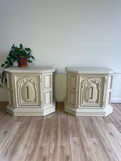 two white nightstands sitting next to each other on top of a hard wood floor