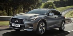 a silver infiniti is driving down the road