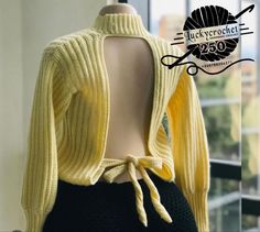 a mannequin wearing a yellow sweater and black skirt