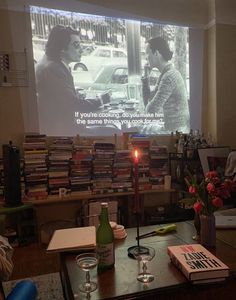 two people sitting at a table in front of a projector screen