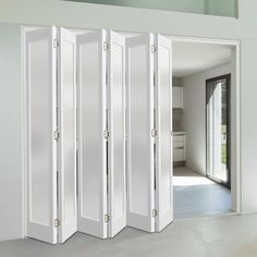 the room divider is open to reveal an empty living area with white walls and doors