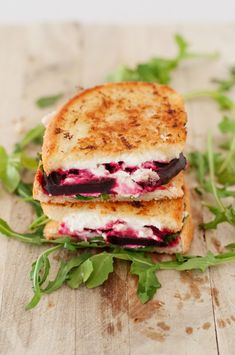 two grilled sandwiches with beets and goat cheese are stacked on top of each other