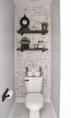 a white toilet sitting in a bathroom next to a shelf filled with towels and other items