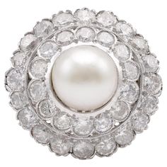 Center Stone: Pearl Weight: 9.1mm Accent Stone: 34 Diamonds Cut: Round Brilliant, Single Weight: Approximately 2.7 Carats Color: I Clarity: SI Metal: 14K White Gold Era: Art Deco Circa: 1930s Hallmarks: 14K Purity Marks Size: 5.5 and can be resized Gram weight: 7.67 This exquisite Art Deco ring from the 1930s showcases a stunning 9.1mm pearl at its center, exuding timeless elegance. Surrounding the pearl are 34 sparkling diamonds in round brilliant and single cuts, totaling approximately 2.7 car Luxury Pearl Ring With Round Cut Center Stone, Luxury White Cluster Pearl Ring, Engagement Ring Quiz, Art Deco Pearl, Colored Stone Engagement Rings, Yellow Gold Cocktail Ring, Halo Style Engagement Rings, Unique Rings Vintage, Vintage Cocktail Ring