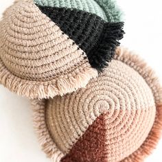 three knitted hats with tassels on top of each one in different colors