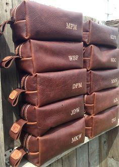 a stack of brown leather bags sitting on top of a wooden fence