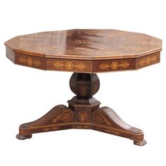 a wooden table with an ornate design on it's top and two circular legs