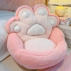 a pink dog bed with paw prints on it