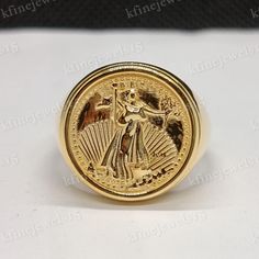 a gold ring with an image of a woman holding a fan on it's side