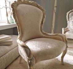 an old chair sitting on top of a carpeted floor next to a white couch