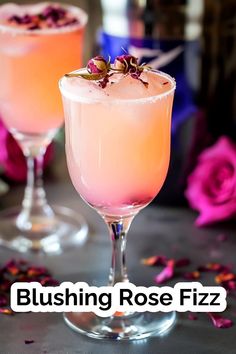 two glasses filled with pink liquid and garnished with flowers on the rims