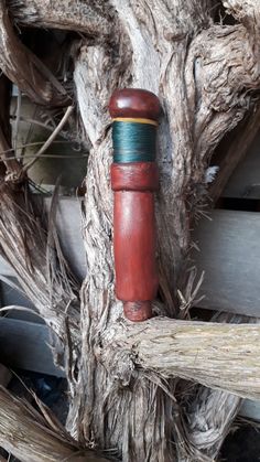 a red fire hydrant sitting on top of a wooden fence next to a tree