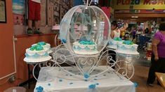 there are many cakes on display in the store and one is under a glass dome