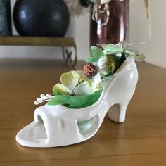 a white shoe with flowers in it sitting on a table