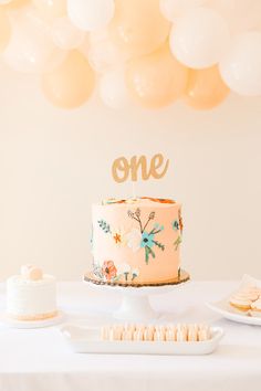 a table with a cake and some balloons