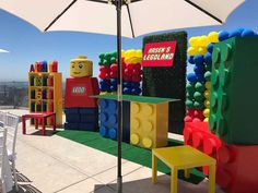 an umbrella on top of a building made out of legos and other items that are in different colors