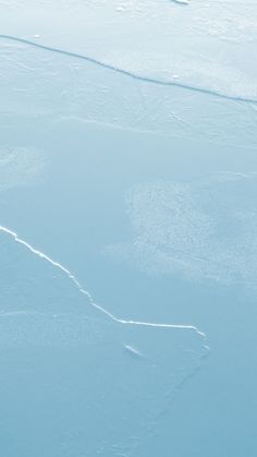 a man riding skis down the side of a snow covered slope next to an ocean