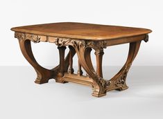 an antique wooden table with carvings on the top and bottom, against a white background