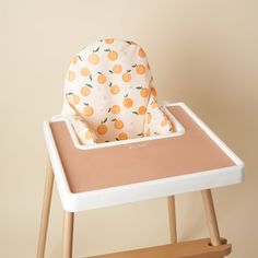 a baby's highchair with a cloth in the middle and an orange print on it