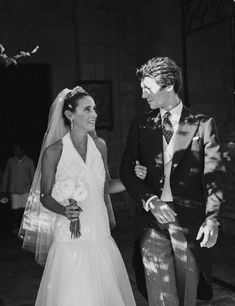 a bride and groom walking down the aisle at their wedding ceremony in black and white