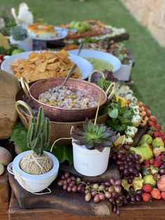 an assortment of fruits and vegetables on a table with bowls of dips, crackers, cornbreads, fruit