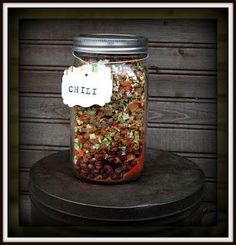 a jar filled with lots of food sitting on top of a wooden table next to a wall