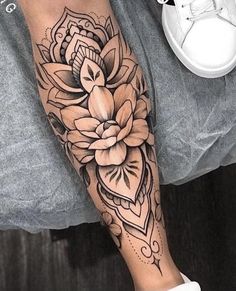 a woman's leg with a flower tattoo on it