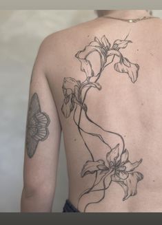 a woman's back with flowers and butterflies on it