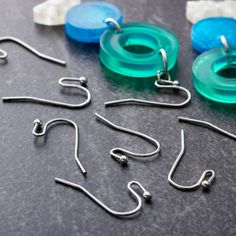 several different types of fishing hooks are on the table next to some plastic discs and other items