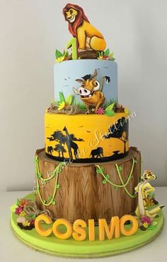 a three tiered cake with the lion king and jungle animals on it's sides