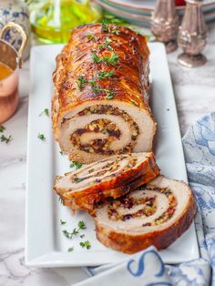 sliced meatloaf on a white platter with garnish and parsley