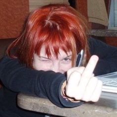 a woman with red hair is holding her cell phone up to the camera and pointing