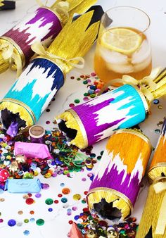 colorful party supplies and confetti on a white table with glasses, lemons, and streamers