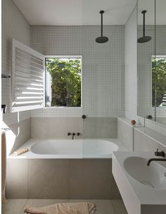 a bathroom with two sinks and a large bathtub in it's center area