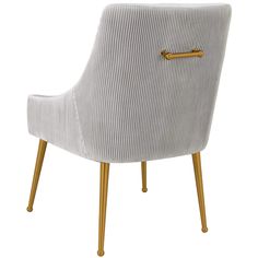 an upholstered white chair with gold legs