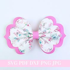 a pink and white flowered hair bow on a white background