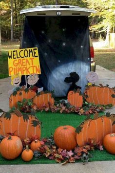 pumpkins are arranged in front of a van with a sign that says welcome great pumpkin