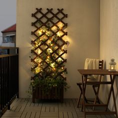 a wall mounted planter with lights on it next to a table and chair in a room