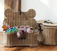 two wicker baskets with teddy bears and toys in them on a wooden floor next to a mirror