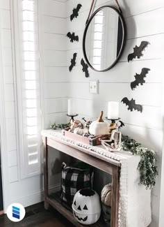 a halloween decorated entryway with pumpkins and bats on the wall