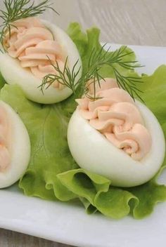 four deviled eggs on lettuce with dill