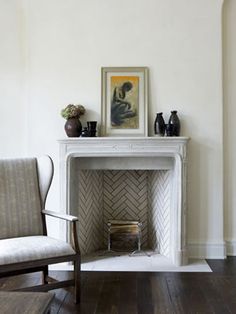 a living room with a fire place and two chairs