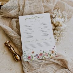 a wedding program sitting on top of a table next to a gold bottle and flowers