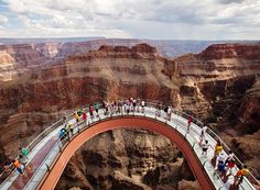 people are walking across a bridge in the grand canyon