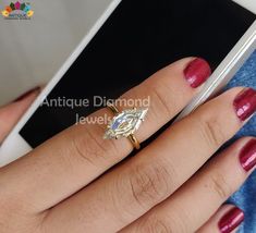 a woman's hand with a ring on top of her finger and red nail polish