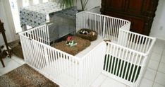 two white baby gates in the middle of a living room with rugs on the floor