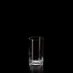 an empty glass on a black surface with only one object visible in the photo and no background