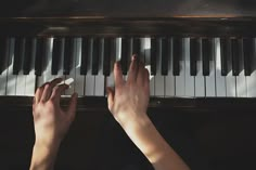 two hands are playing the piano with their fingers