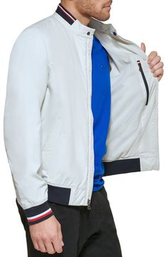 Subtle logo detailing adds signature touches throughout this lightweight bomber jacket with dual front-slant pockets and ribbed banding at the collar and cuffs. 28 1/2" length Stand collar with snap-tab closure Lined 90% polyester, 10% spandex Machine wash, tumble dry Imported Casual Tommy Hilfiger Outerwear For Spring, Tommy Hilfiger Casual Spring Outerwear, White Outerwear With Ribbed Collar For Spring, Casual White Outerwear With Elastic Cuffs, White Ribbed Collar Outerwear For Spring, Fitted Casual Track Jacket With Ribbed Cuffs, Casual Long Sleeve Track Jacket With Padded Collar, Spring Workwear Windbreaker With Ribbed Cuffs, Spring Windbreaker With Ribbed Cuffs